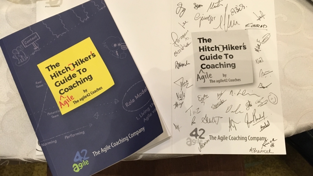 Copy of The Hitchhiker’s Guide to Agile Coaching signed by agile42 coaches